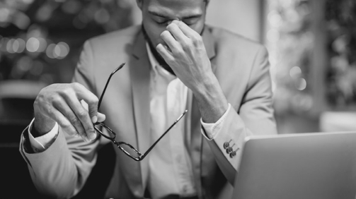 Problems At Work. Tired Black Businessman Massaging His Nose Bridge Holding Glasses Working In Restaurant