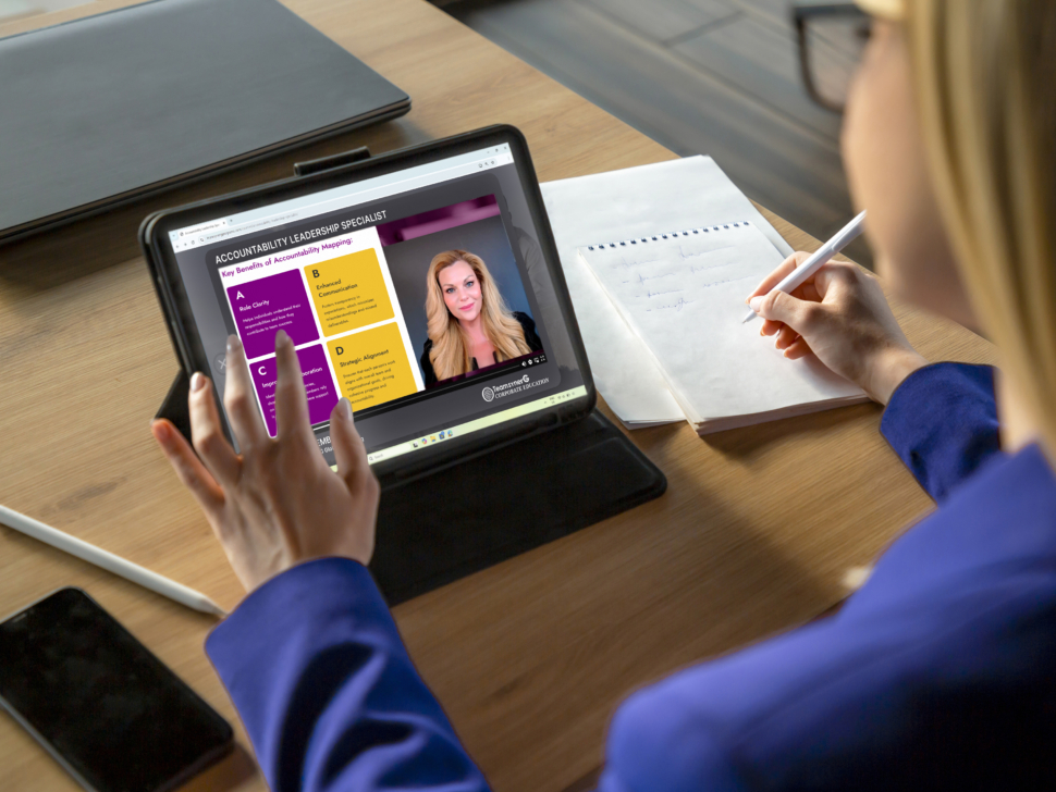 Female Professional Reviewing Digital Resume in Modern Office | TeamsynerG Global Consulting