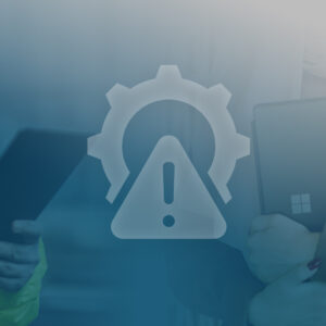 Two technicians using tablets with a large warning and gear icon overlay in the foreground (IT maintenance vibe).